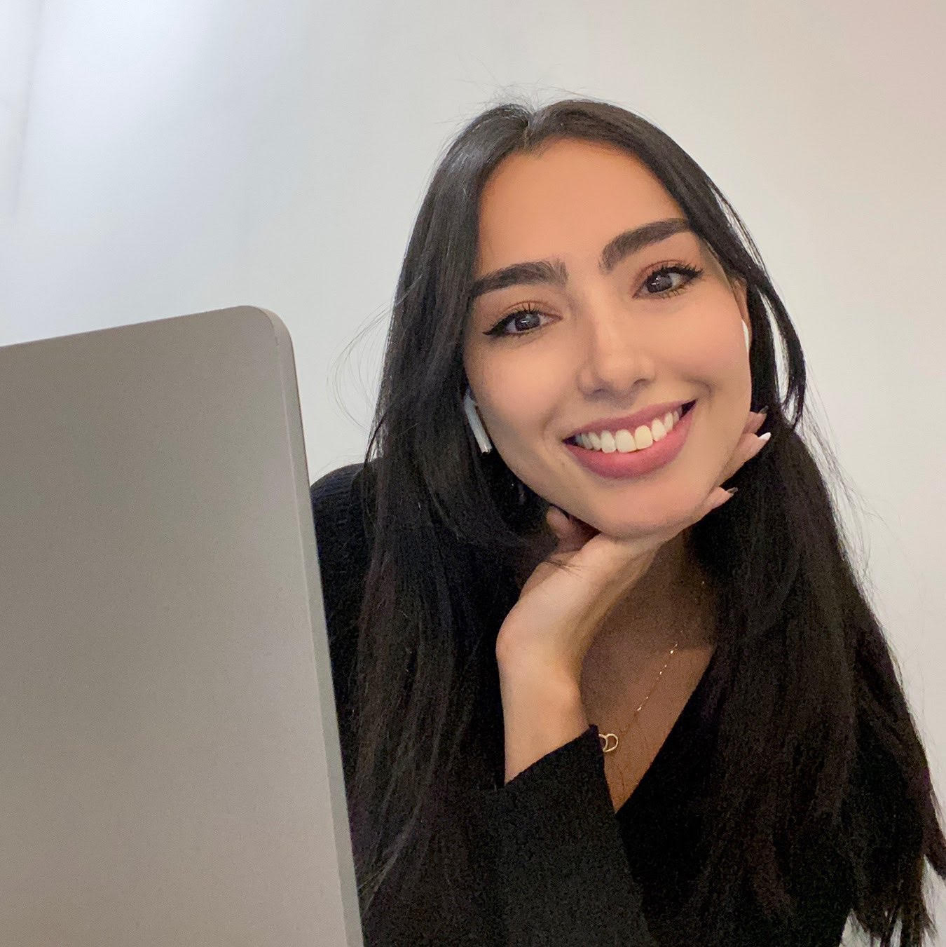 Smiling Ale in front of her laptop